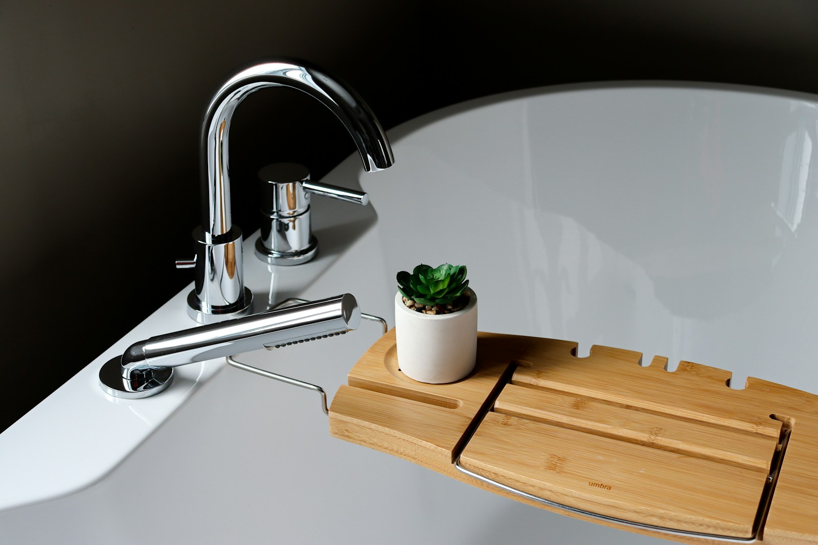 Bathroom basin with a wooden tray and succulent