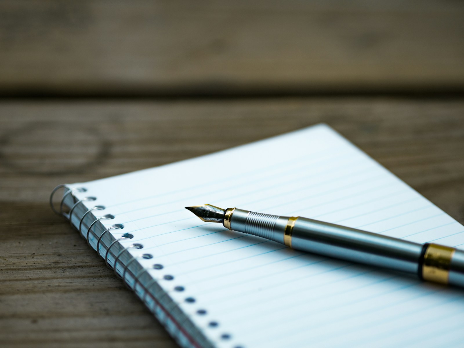 Pen and notebook on a wood surface